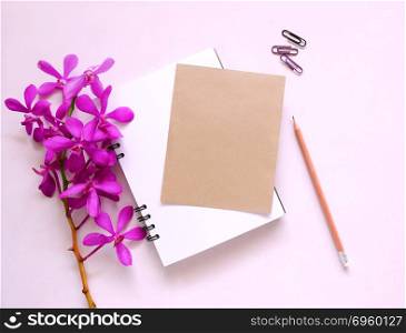 Blank brown greeting card with orchid flowers on pink background.. greeting card with orchid flowers
