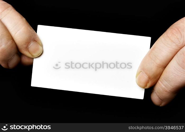 Blank business card in hands over black background
