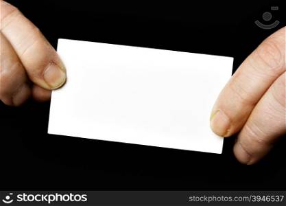 Blank business card in hands over black background