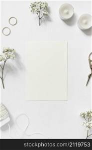 blank card surrounded with gypsophila wedding rings string scissor white background