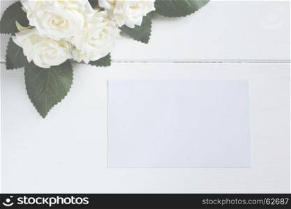 Blank card with flower bouquet on wooden table.