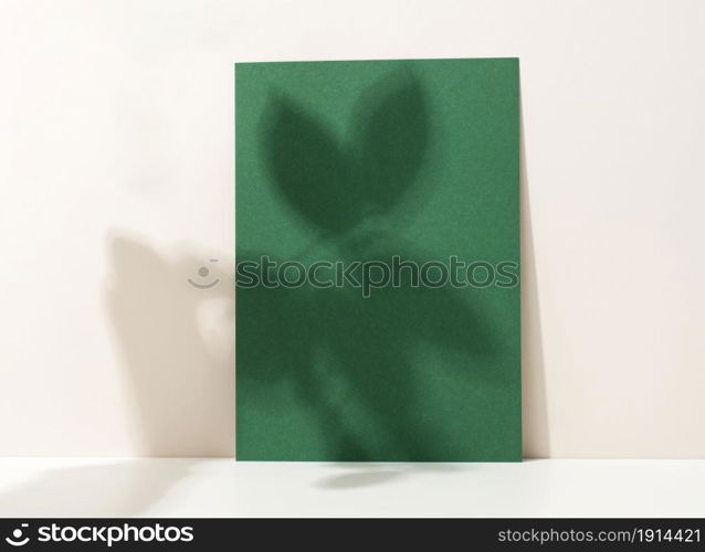 blank cardboard sheet of paper with shadow on white table. Template for flyer, announcement