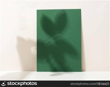 blank cardboard sheet of paper with shadow on white table. Template for flyer, announcement