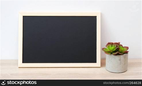 Blank chalkboard and succulant plant standing on wood table isolated on white background, banner, space for text, mock up, product display montage
