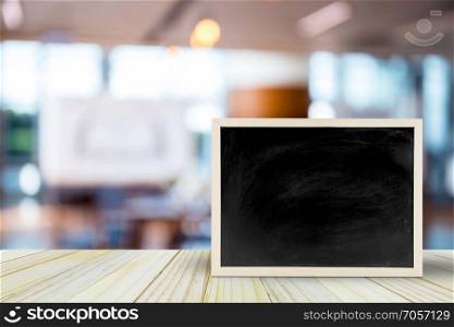 Blank chalkboard on table over blur restaurant with bokeh background, space for text, mock up, product display montage
