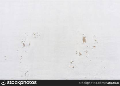Blank concrete wall painted white with flacky weathered paint texture