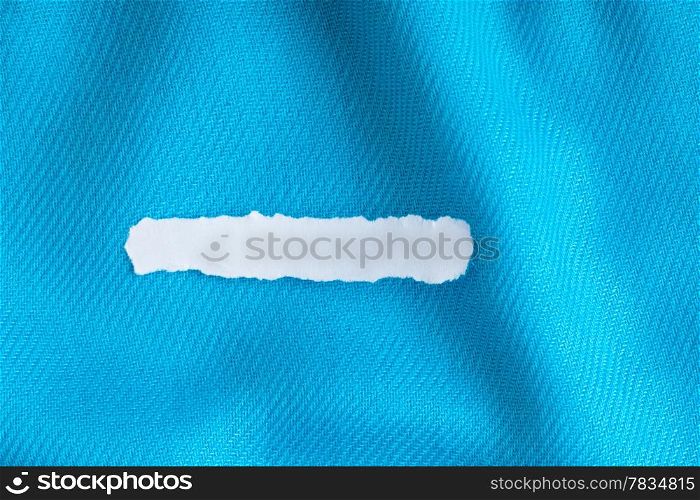 Blank copy space scrap of paper on blue background cloth wavy folds of textile texture material