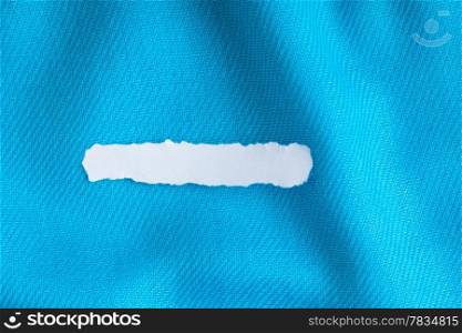 Blank copy space scrap of paper on blue background cloth wavy folds of textile texture material