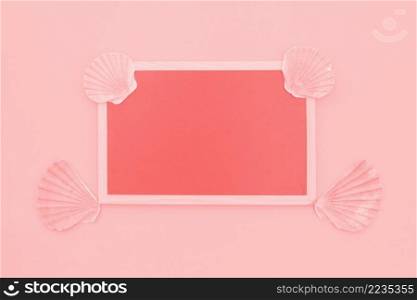blank coral frame decorated with scallop seashells pink background