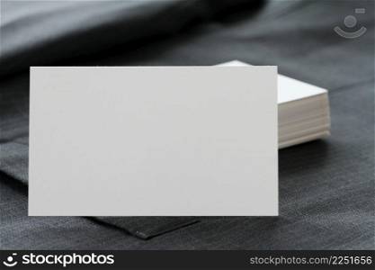 Blank corporate identity package business card with dark grey suit  background.