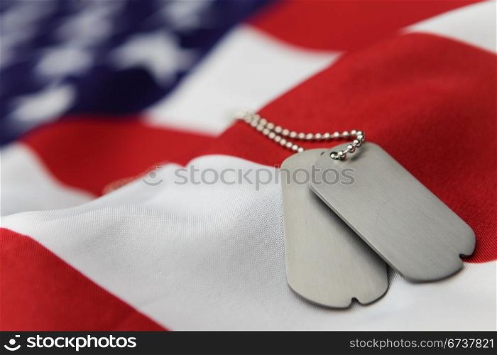 Blank dog tags on American flag with focus on tags - Shallow dof