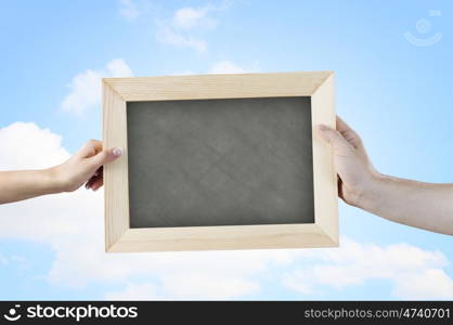 Blank frame. Close up of hands holding blank chalkboard