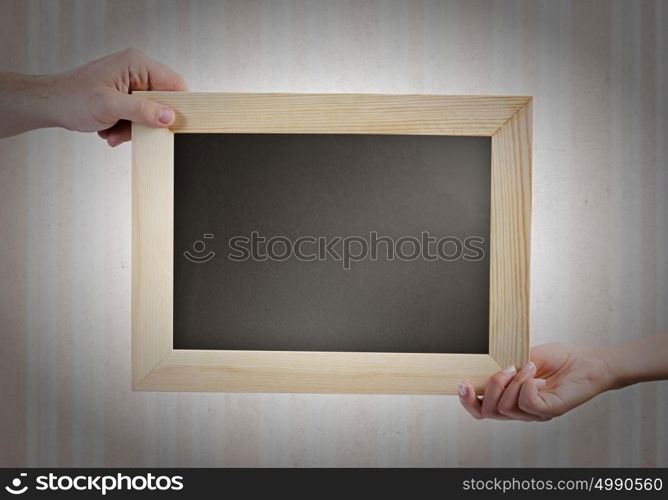 Blank frame. Close up of hands holding blank chalkboard