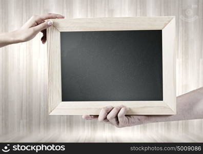 Blank frame. Close up of hands holding blank chalkboard