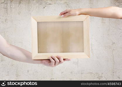 Blank frame. Close up of human hands holding blank frame