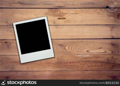 Blank frame photo on wood background with space.