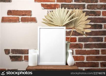 blank frame shelf beside vase with dry leaves