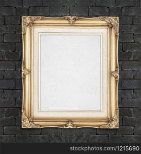 Blank Gold color vintage photo frame hanging on black brick wall,template for adding your photo.