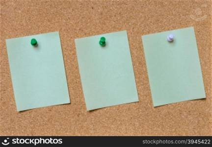 Blank green paper posted on cork board with tack pin for text and background