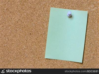 Blank green paper posted on cork board with white tack pin for text and background