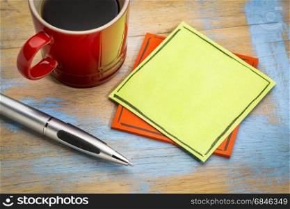 blank green sticky note with a pen and a cup of coffee