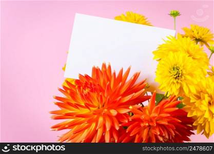 Blank greeting card in a bouquet of yellow and red summer flowers on a pink background. Holiday invitation, place for text.. Blank greeting card in bouquet of yellow and red summer flowers on pink background. Holiday invitation, place for text.