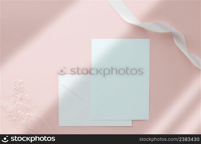 Blank greeting card invitation Mockup 5x7 on envelope with dry flowers and ribbon on pink pastel background, flat lay, mockup