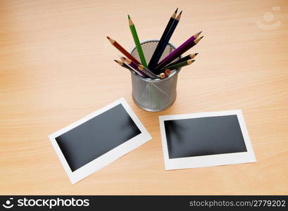 Blank instant photos and pencils on the wooden table