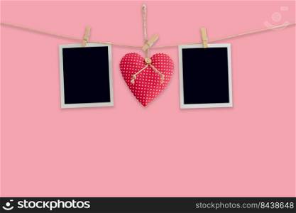 Blank instant photos and red heart hanging pastel color background.