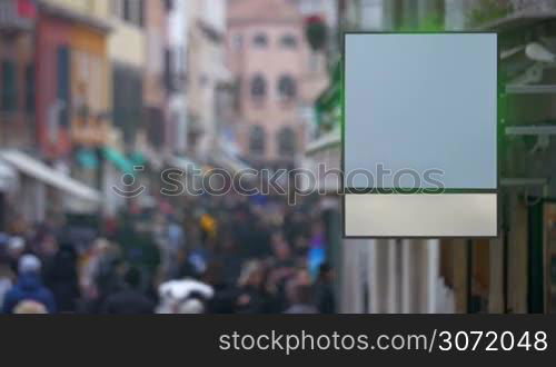 Blank led display hanging on the building in crowded city street. Outdoor advertising and promotion