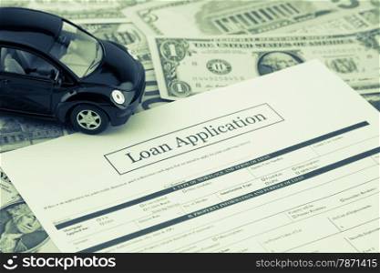 Blank loan application form with car model and money: dollar banknotes on background, Sepia toned