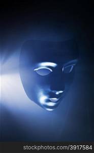 Blank mask in blue hazy light. Short depth of field.