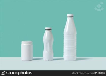 Blank mock-up white plastic bottles different size and shapes on a duotone background with shadows and copy space.. Mock up plastic bottles with shadows.