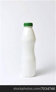 Blank mockup white bottle with green cover for dairy products on a light gray background, copy space.. White plastic bottle mock up for yogurt on a light background.