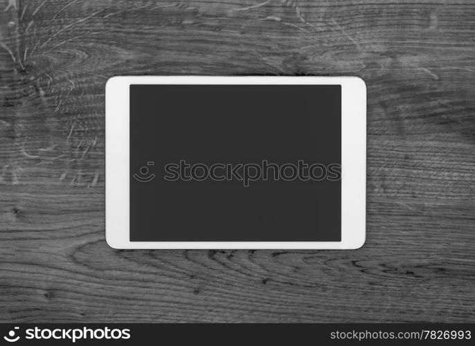 Blank modern digital tablet on a wooden desk. Top view. High quality.