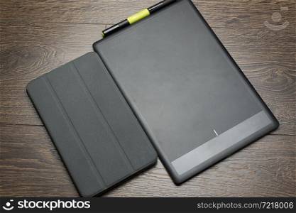 Blank modern digital tablet with papers and pen on a wooden desk. Top view. High quality detailed graphic collage.. Graphic tablet on a white background.