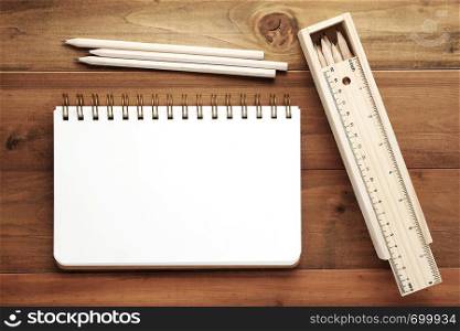 Blank note book ,pencils ,ruler and pencil box on wood background, template with copy space for text
