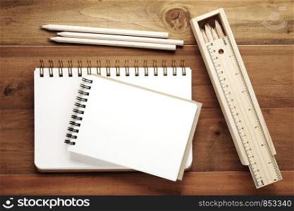 Blank note books ,pencils ,ruler and pencil box on wood background, template with copy space for text