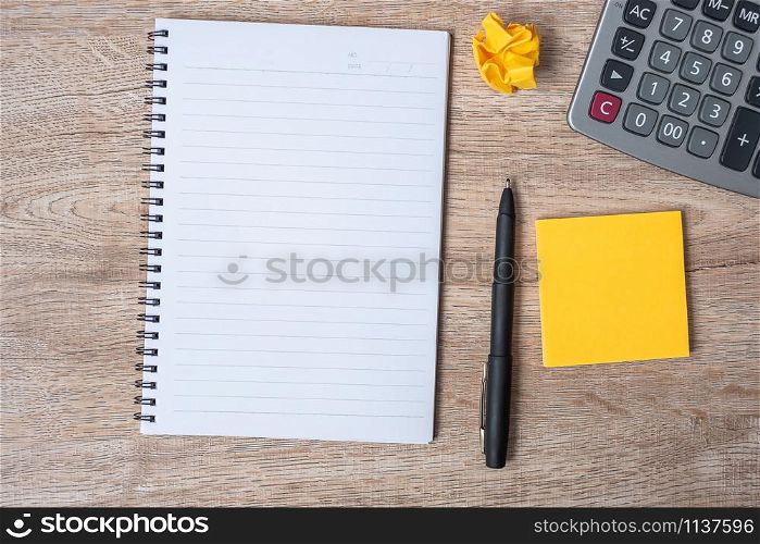 blank note with pen and calculator on wooden table background. marketing, financial concept