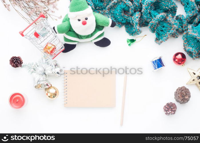 Blank notebook and pencil on white table with Christmas decorations and shopping cart, Top view