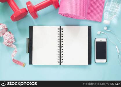 Blank notebook and smartphone with dumbbells, yoga mat, water and measuring-tape on pastel color background, Healthy lifestyle concept