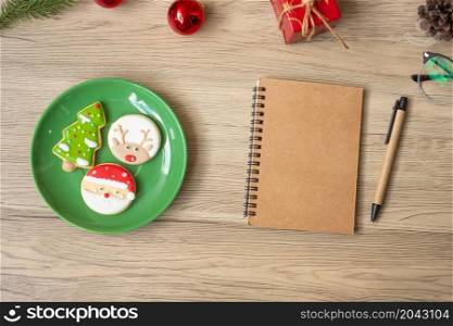 Blank notebook, black, Christmas cookies and pen on wood table, Top view and copy space. Xmas, Happy New Year, Goals, Resolution, To do list, Strategy and Plan concept