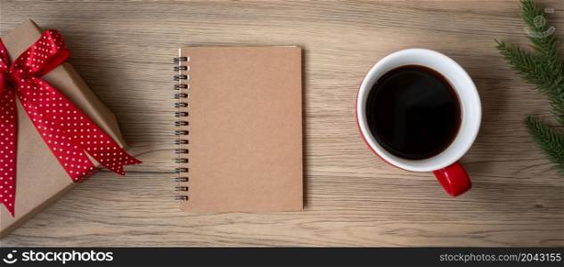 Blank notebook, black coffee cup and Christmas gift on wood table, Top view and copy space. Xmas, Happy New Year, Goals, Resolution, To do list, Strategy and Plan concept