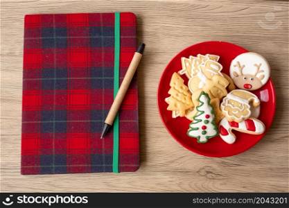 Blank notebook, Christmas cookies and pen on wood table. Xmas, Happy New Year, Goals, Resolution, To do list, Strategy and Plan concept