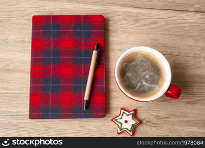 Blank notebook, coffee cup, Christmas cookies and pen on wood table. Happy New Year, Goals, Resolution, To do list, Strategy and Plan concept