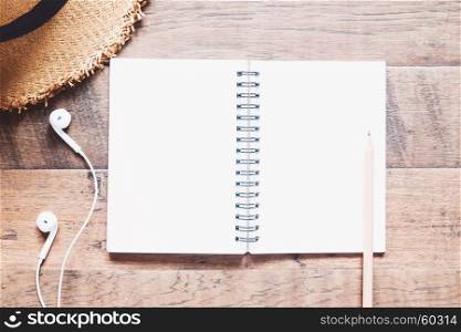 Blank notebook, earphones and hat on wooden table, Travel planning, Lifestyle concept