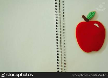 Blank notebook with a cookie with shape of an apple