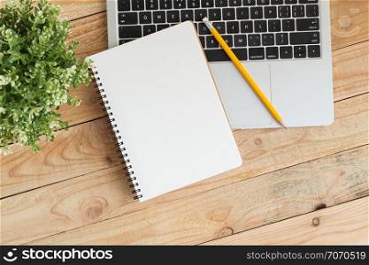 Blank notebook with and pencil on laptop,Flat lay photo of notebook for your message