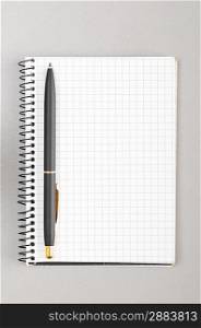 blank notebook with pen on gray