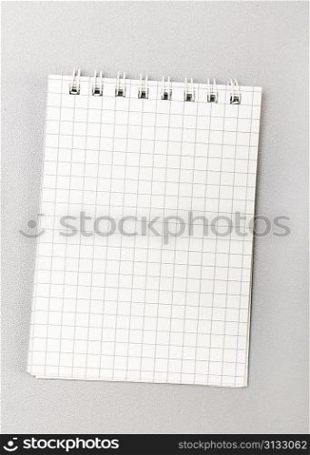 blank notebook with pen on gray